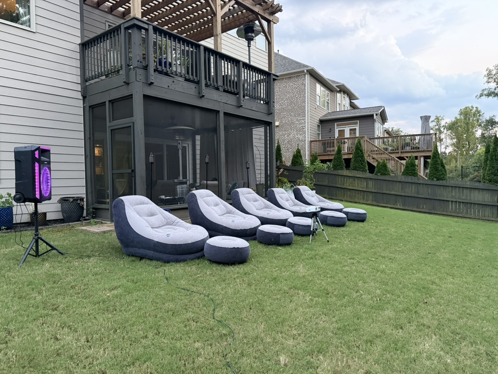 Row of inflatable lounge chairs and projector ready for an outdoor movie night