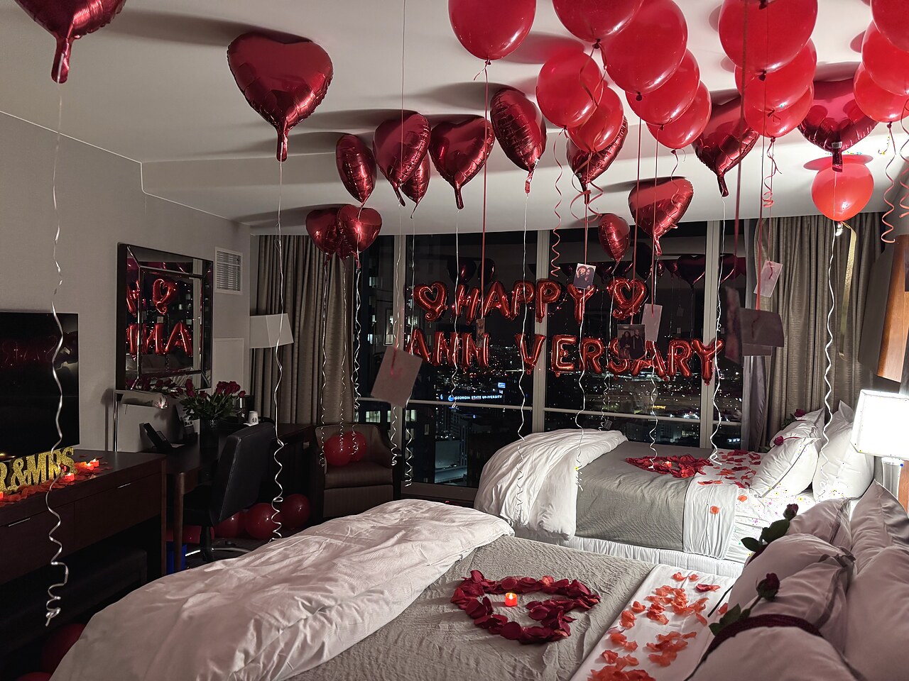 Red balloon anniversary hotel room with rose-petal beds and the Atlanta skyline